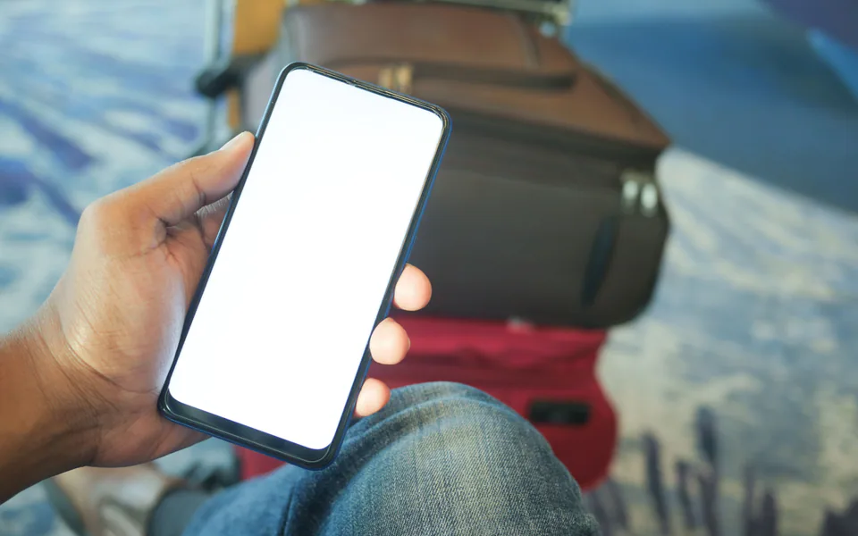 Cestující s telefonem na letišti při článku o internetu v Číně