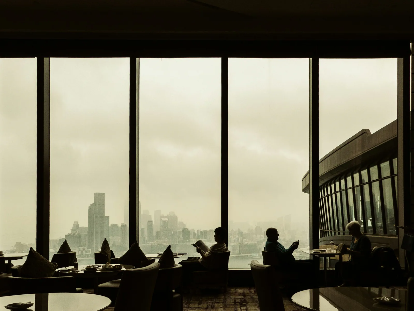 Hostia kaviarne pri okne s výhľadom na Hongkong